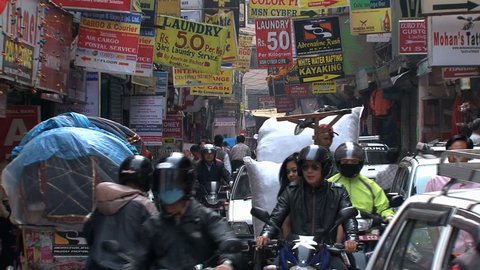 KATHMANDU - CIRCA 2010: People, cars and bikes circulate through the city circa 2010 in Kathmandu.