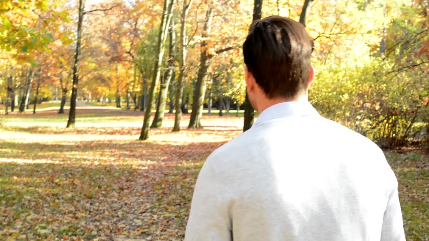 Overall detailed view of a young handsome man who is walks through the woods