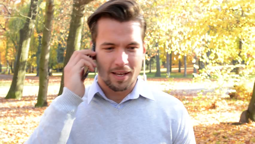 Young handsome man walks through the woods and phone