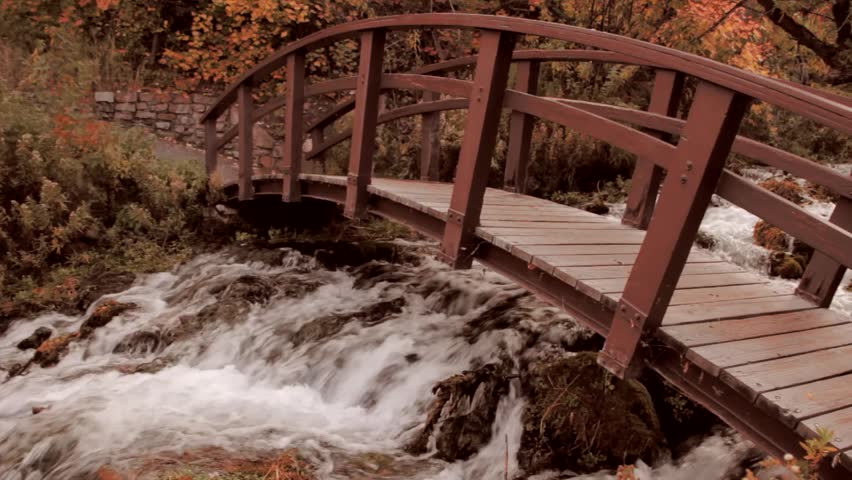 A beautiful footbridge over a mountain stream during the fall season with