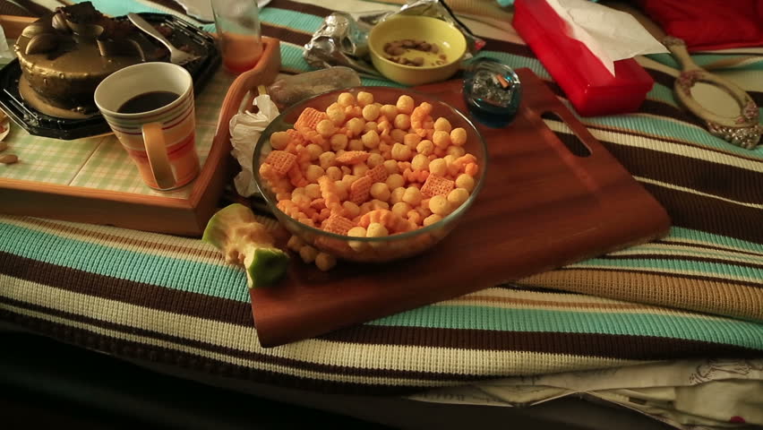 Depressive woman eating chips and watching tv