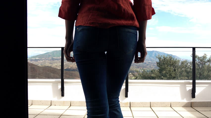 Young woman stretching arms while standing on terrace with mountains view, 4K
