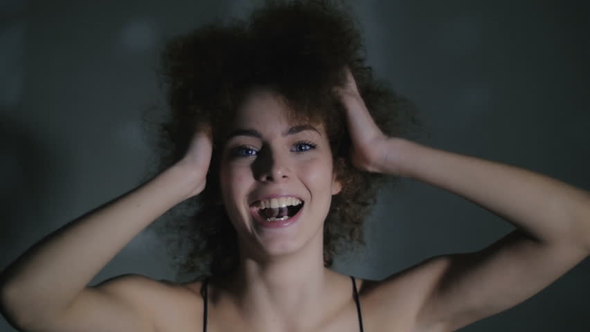 The young girl broadly smiles and has fun. Good emotions overflow the young girl. In slow motion