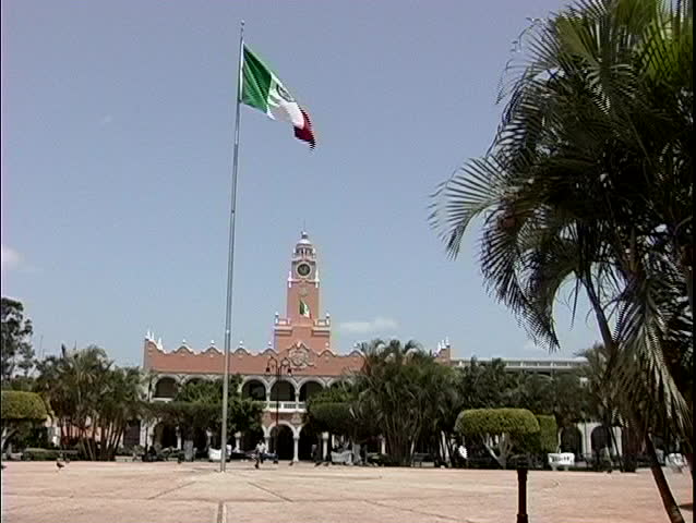 The red, white and green flag of Mexico waves in the breeze in front of the Merida City Hall, Merida, Mexico.