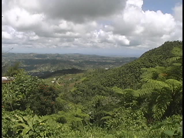 Fluffy white clouds gather above the lush, green Puerto Rican hills.