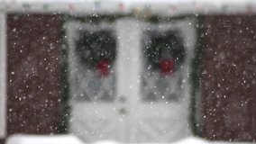 Blurred festive Christmas decorations on doorway outside through the falling snow. - Powered by Shutterstock - Get 15% off with code: PIKWIZARD15
