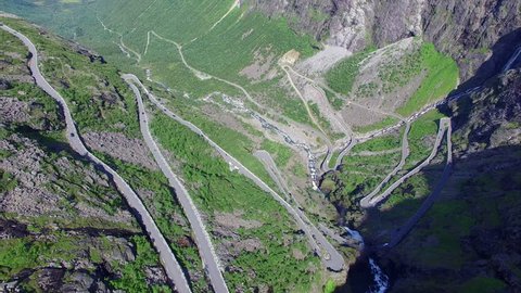 Aerial view of hairpin bends of Trollstigen mountain pass in Norway on sunny summer day, one of the most beautiful roads in the world, major tourist attraction. Aerial 4k Ultra HD.