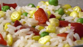Adding seasoning to rice and vegetable salad, close up 4K video