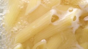Macro video of pasta in boiling water, view from above