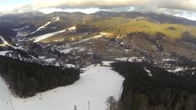 Aerial shot of ski resort Bukovel with snow covered slopes at spring