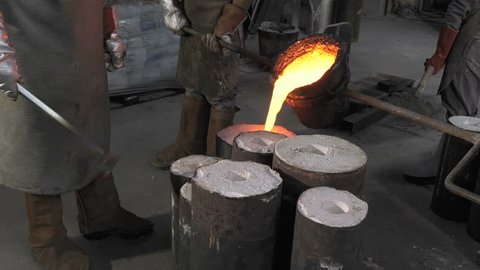 Lost wax bronze casting in a foundry/filling the molds with the molten bronze