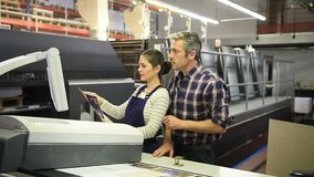 Man working with apprentice in printing house 