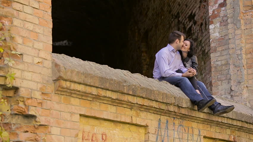 Happy young loving couple bonding to each other while beautiful woman pointing away and smiling