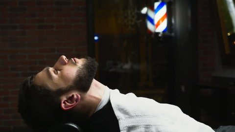 close up barber puts a hot towel on male face slow motion