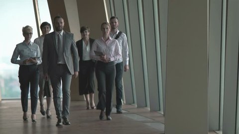 business team, businesspeople  group walking at modern bright office interior