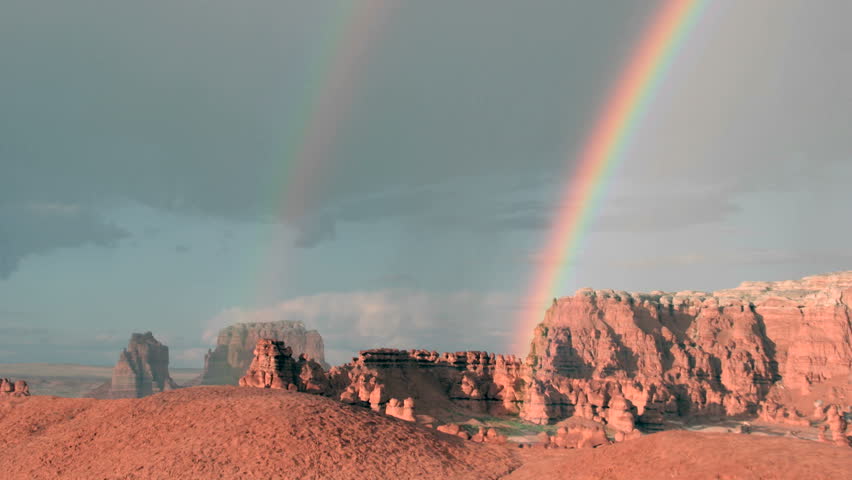 A double rainbow fades until only one remains.