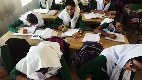 COX'S BAZAR, BANGLADESH, DEC 2015: Muslim Bangladeshi students with hijab in a single sex school studying and writing in their handbooks - listening to teacher - Education in Bangladesh Asia