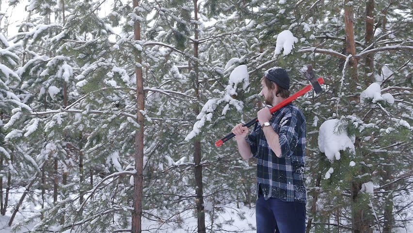 Lumberjack standing with his ax in the woods, light leakage surround him