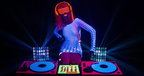 sexy female DJ mixes in a club in UV fluorescent costume