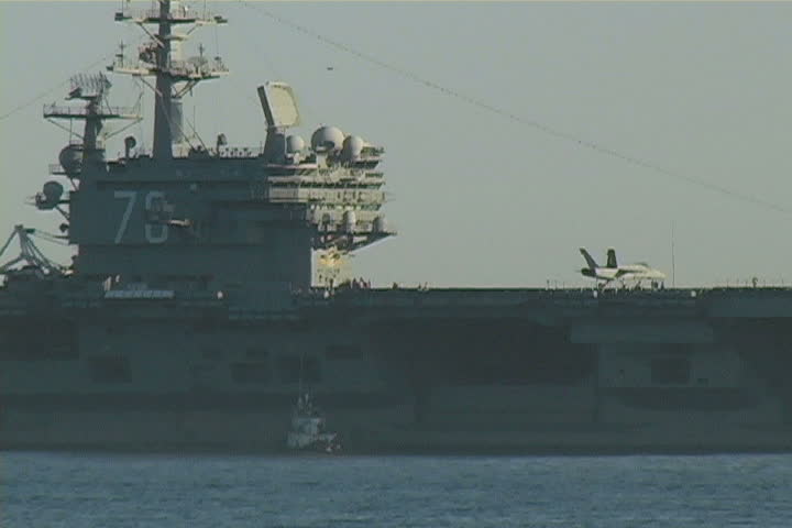 An aircraft carrier near the coast.