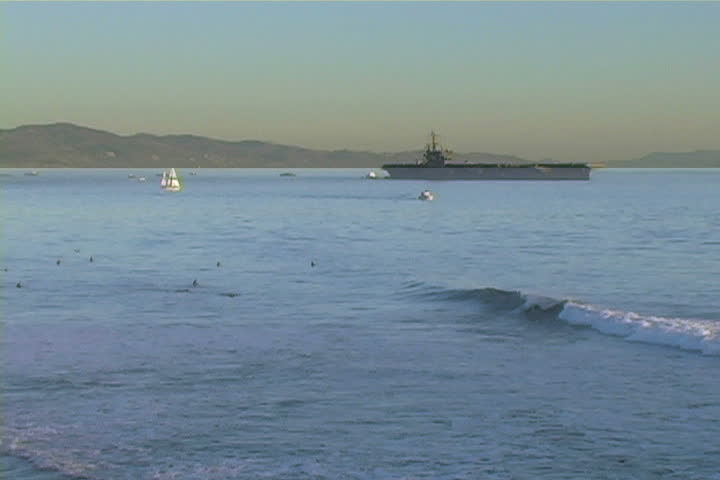 The crew of an aircraft carrier enjoy the day surfing.