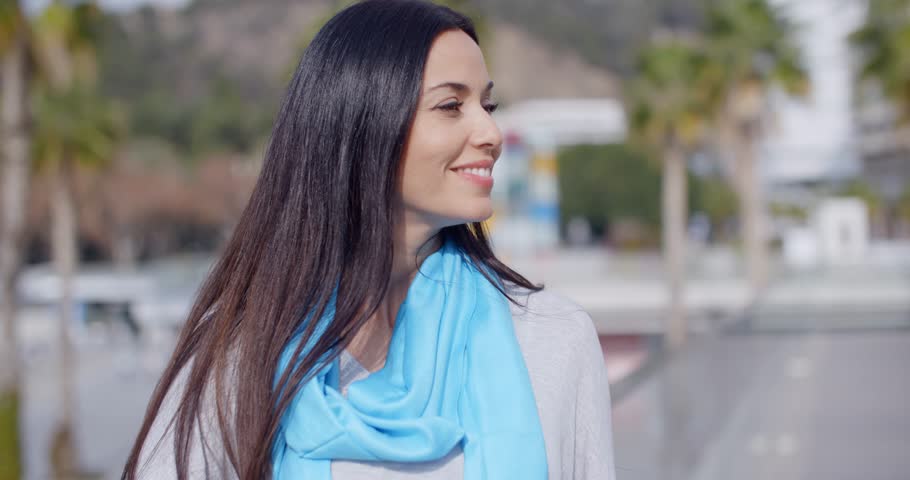 Smiling vivacious young woman in an urban street