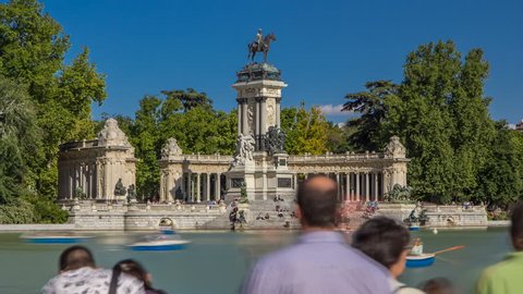 Tourists on boats at Monument to Alfonso XII timelapse hyperlapse in the Parque del Buen Retiro - Park of the Pleasant Retreat in Madrid, Spain