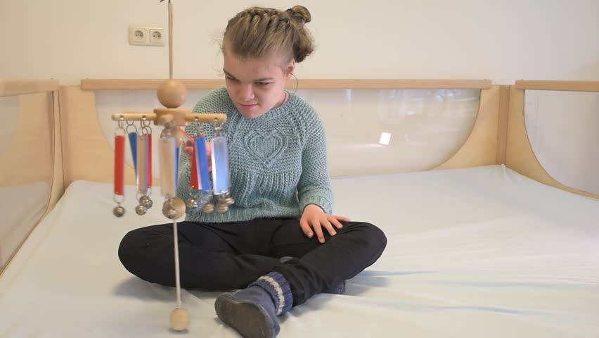 A disabled child having play therapy together with a special needs carer.