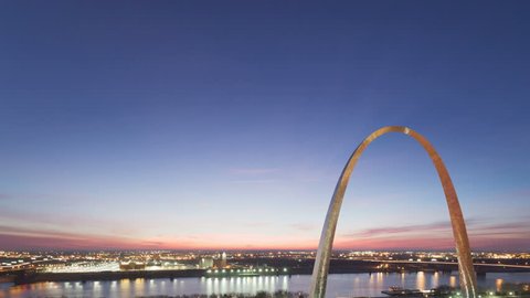 4K Time lapse tilt shot aerial view St Louis Gateway Arch at sunrise with boat traffic on the river and red colored clouds