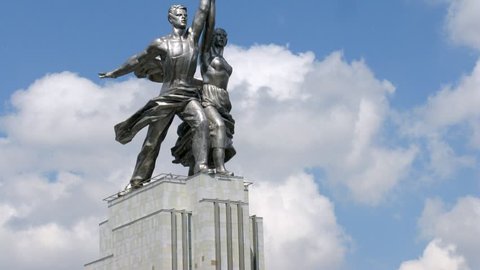 Worker and Kolkhoz Woman in front of passing clouds, side view, time lapse