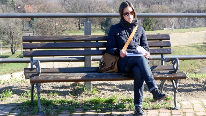 Young woman sitting in the park and reading.