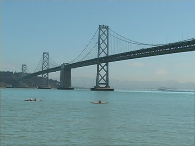 Kayakers paddling in front of the Bay Bridge. 