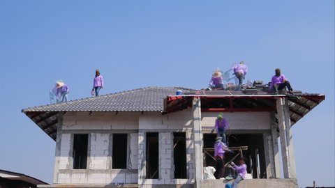 NAKHON RATCHASIMA -FEB 10 : unidentified construction workers installing roof tiles for home building on February 10, 2016 in Nakhon Ratchasima, Thailand
