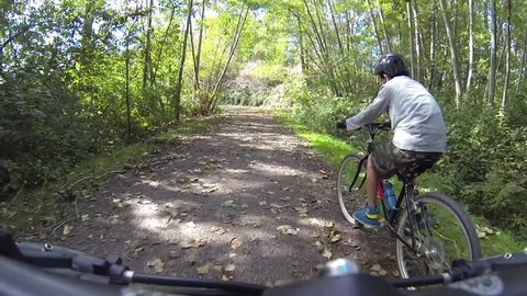 POV video of a mountain biker riding through the trails on a sunny day.