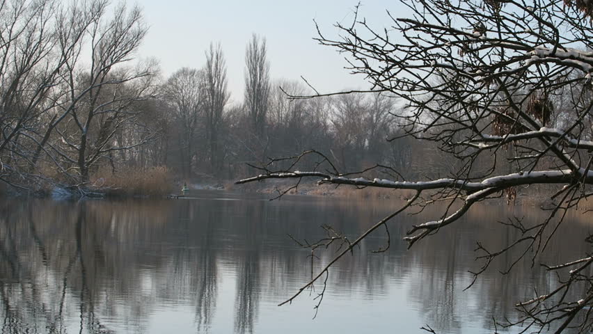 Winter on Havel river. willow tries along the river reflecting in the water. blue sky and sunshine.