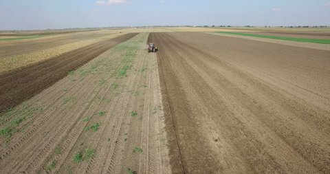 Aerial view of tractor cultivating soybean stubble field
