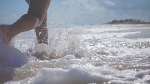 extreme slow motion of woman legs running splashing into water