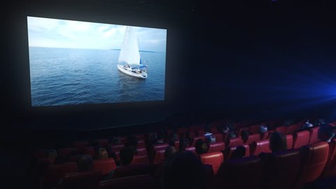 Group of people are watching a drama film screening in a movie cinema theater.
