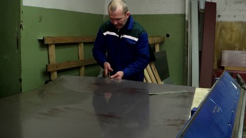 smith work with cold metal in a dirty underground workshop