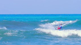 Extreme sports video background. Kitesurfing athlete rides on high waves on sea