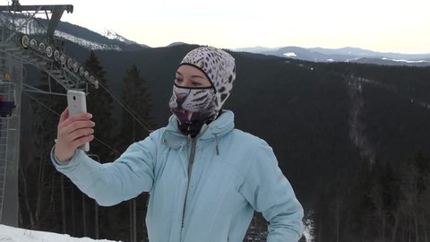 4K Shot Of Girl in Funny Ski mask Taking Selfie On Mountain Top