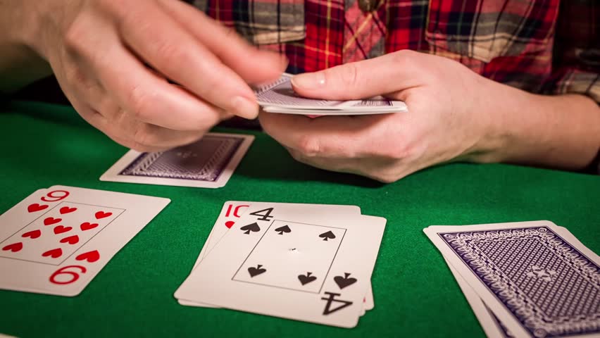Close up of female hands holding cards and playing solitaire