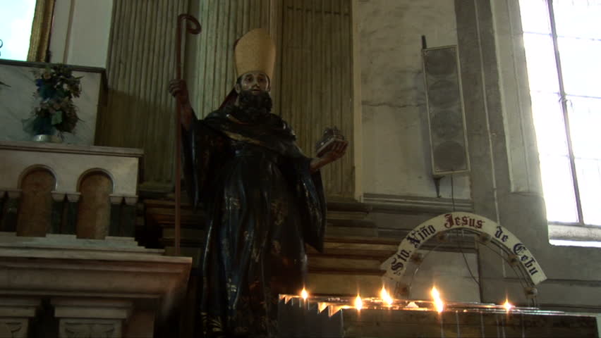 Statue and candles inside the San Agustín Church in Manila, Philippines
