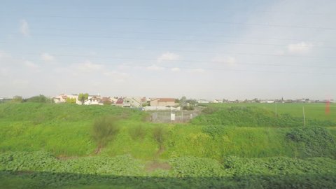 The view from the window of a train, walking along a green field in Israel