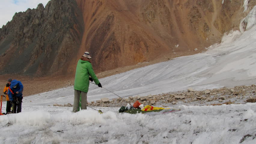 team of mountaineers installing tent on the glacier