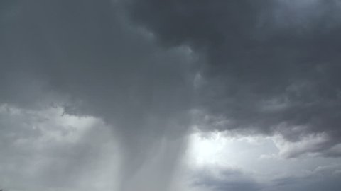 Lightning bolts strike rain shafts, clouds during summer monsoon storm over Arizona desert. 1080p 