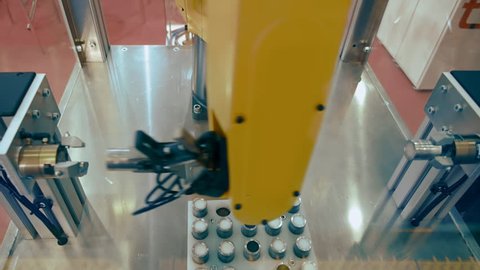 Industrial robot manipulator yellow color in the assembly shop is preparing items for later use on the automated line. Shot in motion