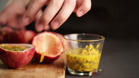 Chef cuts a passion fruit to extract juice and seeds. Fast motion
