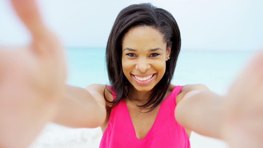 portrait leisure recreation lifestyle beautiful ethnic African American female smiling messaging freedom healthy outdoor beach waves RED DRAGON