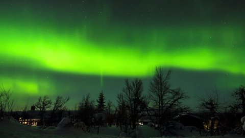 Winter landscape in northern hemisphere with long recording of spirals of northern lights (Auroa borealis), moving stars and moving shadows cast by moonlight